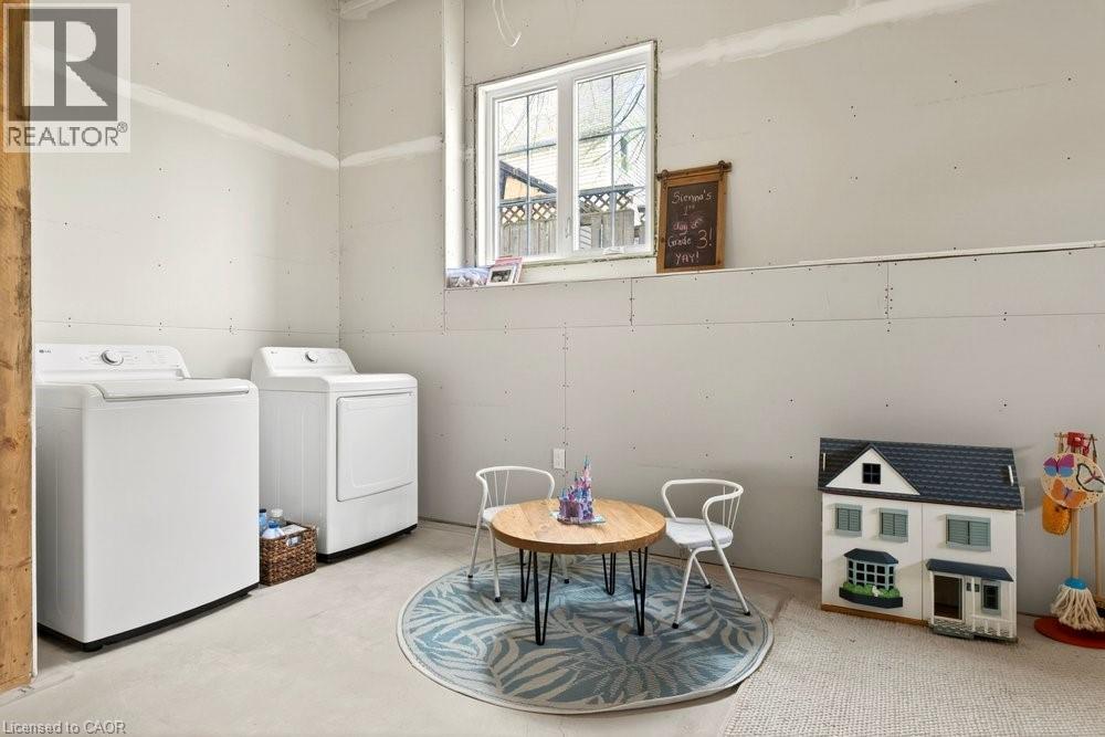 Dedicated utility space featuring a washer and dryer set, drywall-finished walls, and a window providing natural light