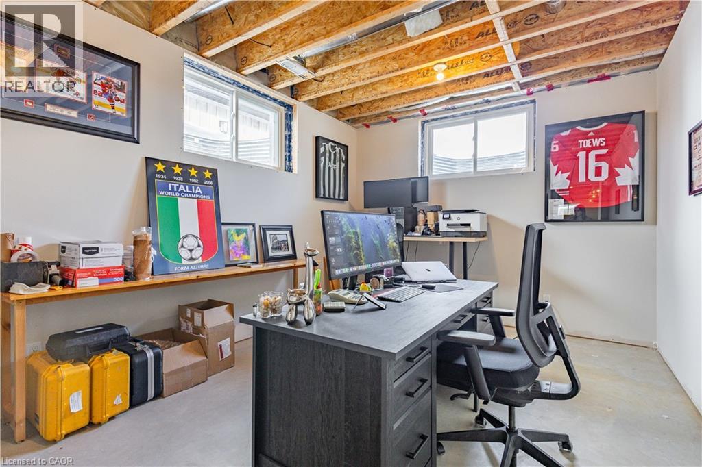 Finished basement space featuring exposed ceiling joists and concrete flooring