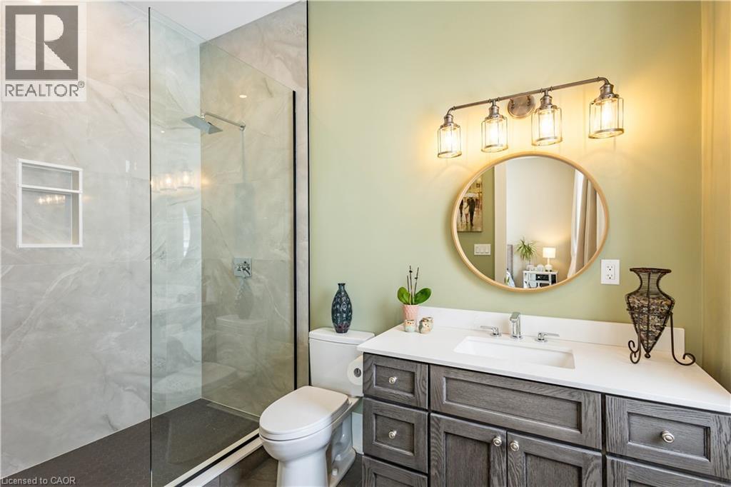 Modern bathroom featuring a frameless glass shower enclosure with marble-look tile walls and a built-in shower niche