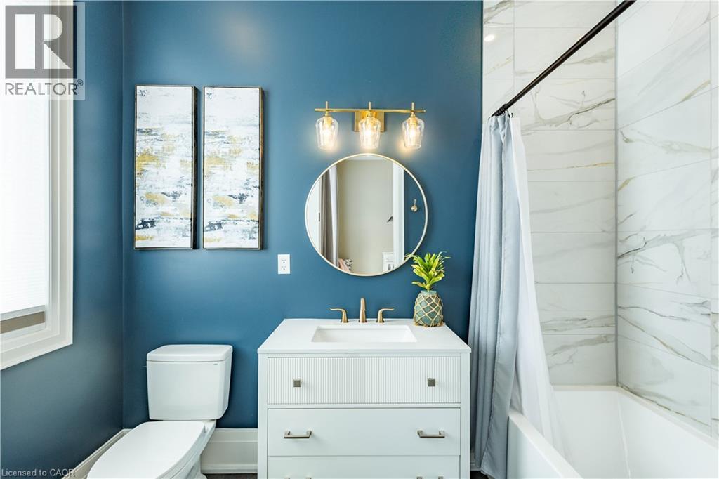 Bathroom featuring a white vanity with integrated sink, brass-finish faucet, and coordinating mirror