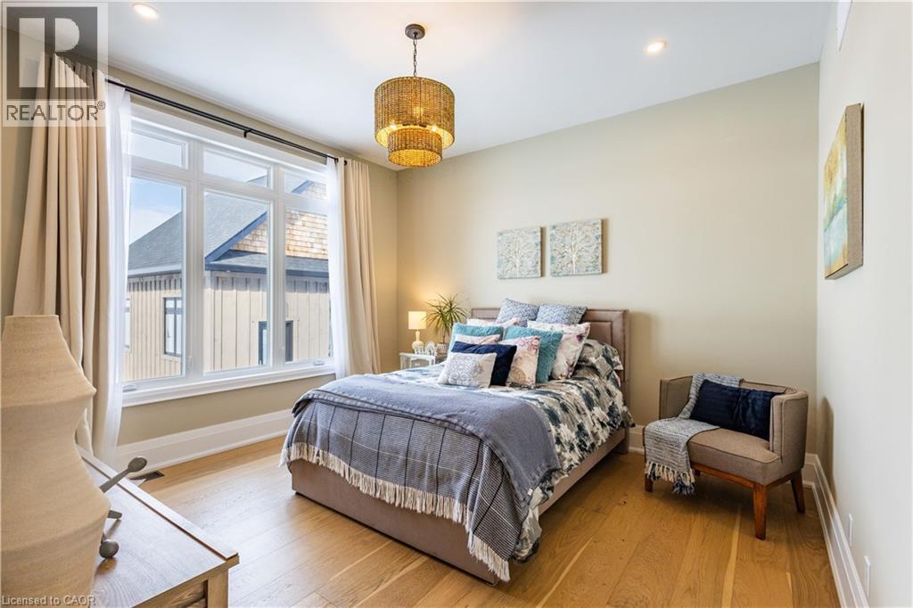 Spacious room featuring wood-finish flooring, a large multi-pane window, and a woven pendant light fixture