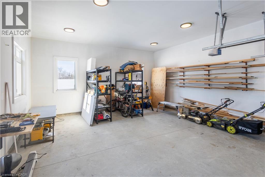 Spacious garage featuring a concrete floor, two windows providing natural light, and overhead lighting