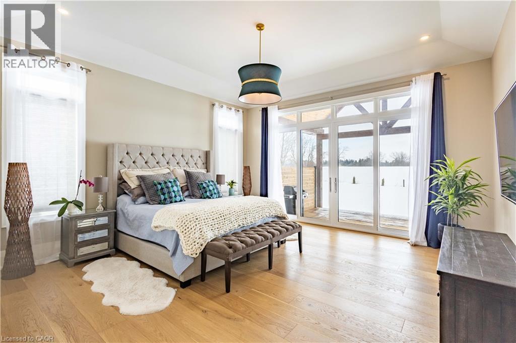Spacious room featuring light wood-finish flooring, a tray ceiling, and dual windows