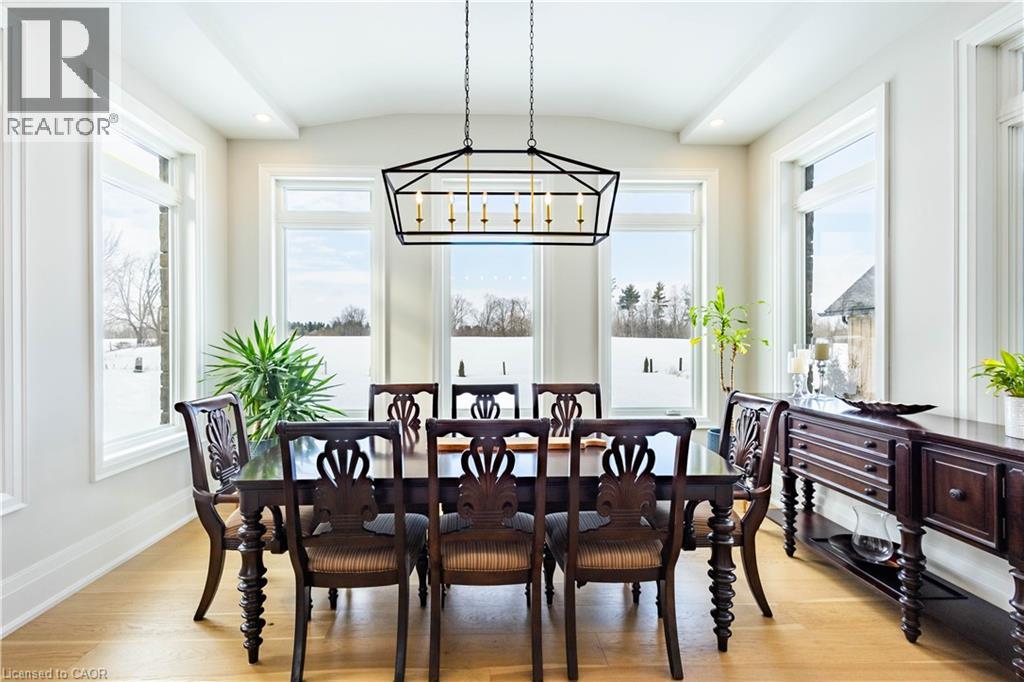 Dining area featuring a contemporary geometric chandelier, a coffered ceiling, and light wood-finish flooring