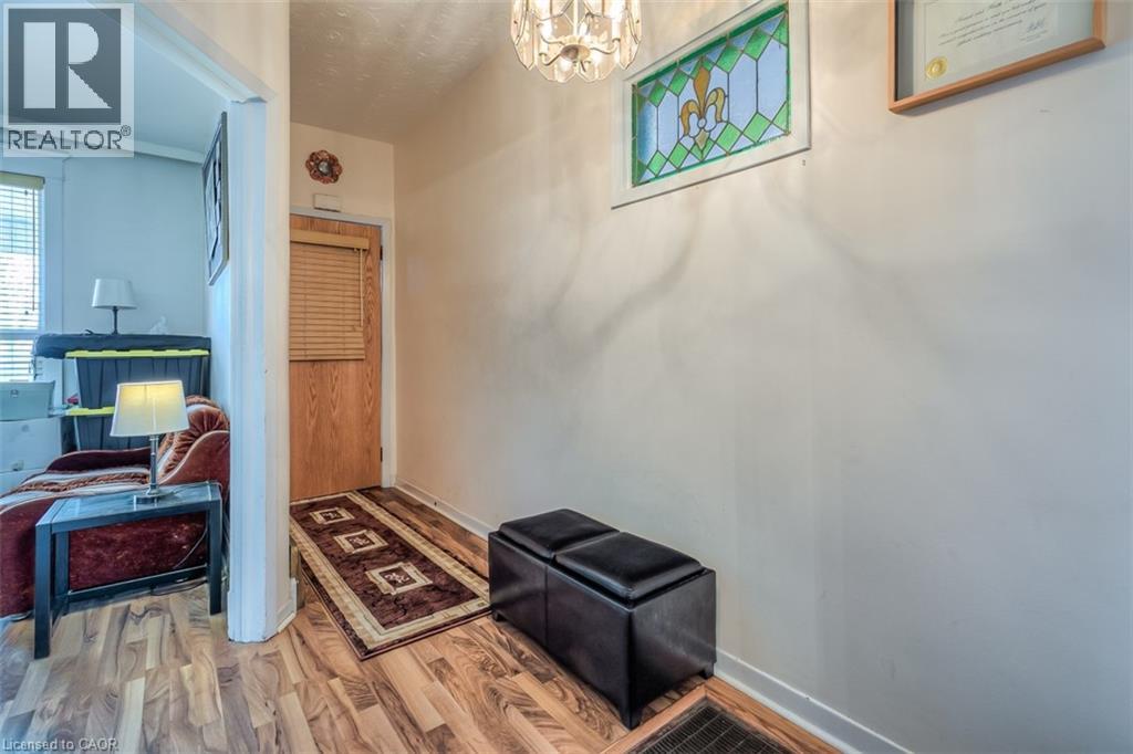 Entryway featuring wood-finish flooring, a wood door with horizontal blinds, and a decorative stained-glass window