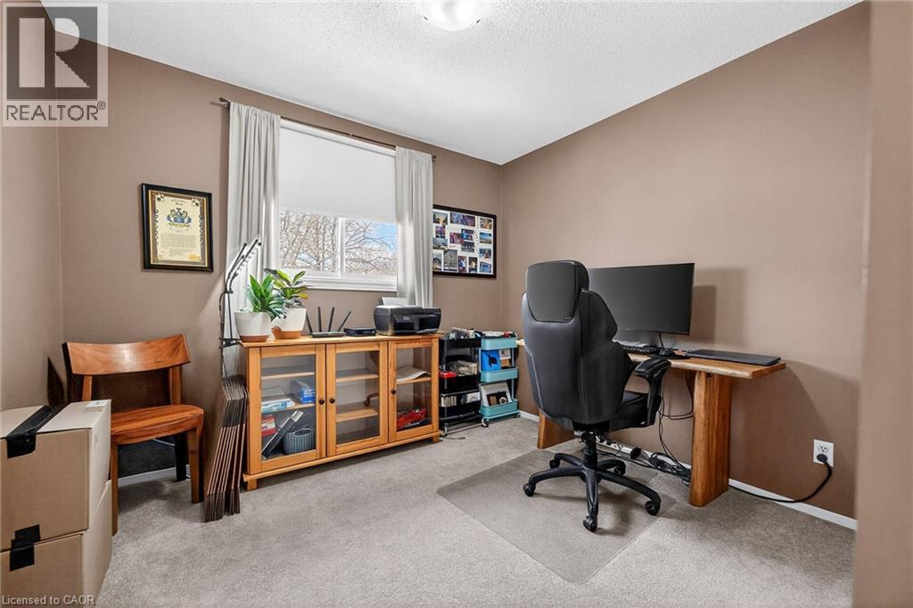 This room features neutral-toned walls, gray carpeting, and a window providing natural light