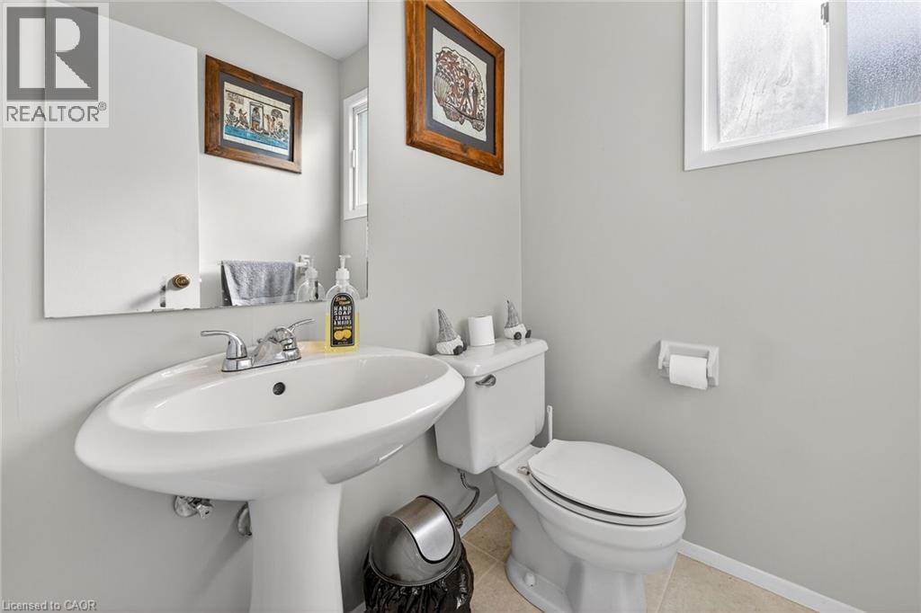 The bathroom features a white pedestal sink with a chrome faucet and a white toilet