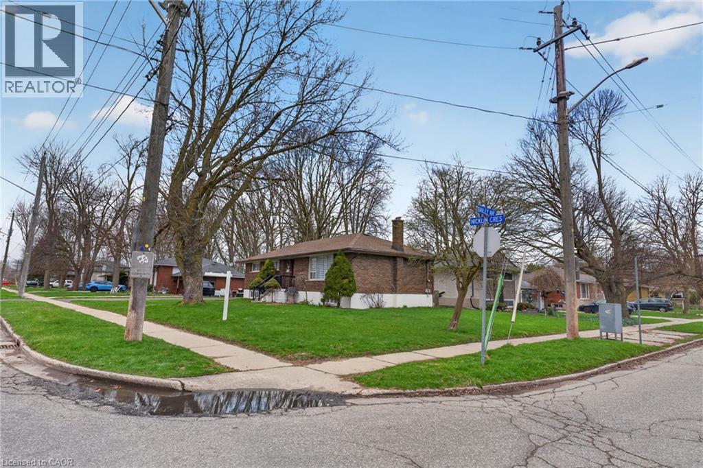 Corner lot featuring a brick exterior and a green lawn