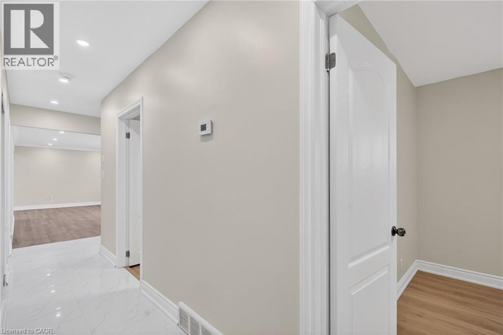 Hallway with recessed lighting, white baseboards, and light neutral wall paint
