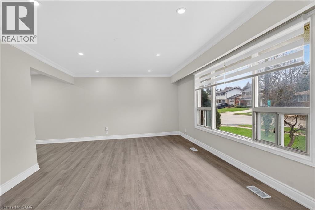 Spacious room with wood-finish flooring, recessed lighting, and crown molding