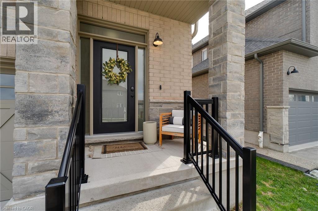 Inviting entryway featuring a dark-framed door with a glass insert, flanked by a transom window and sidelight
