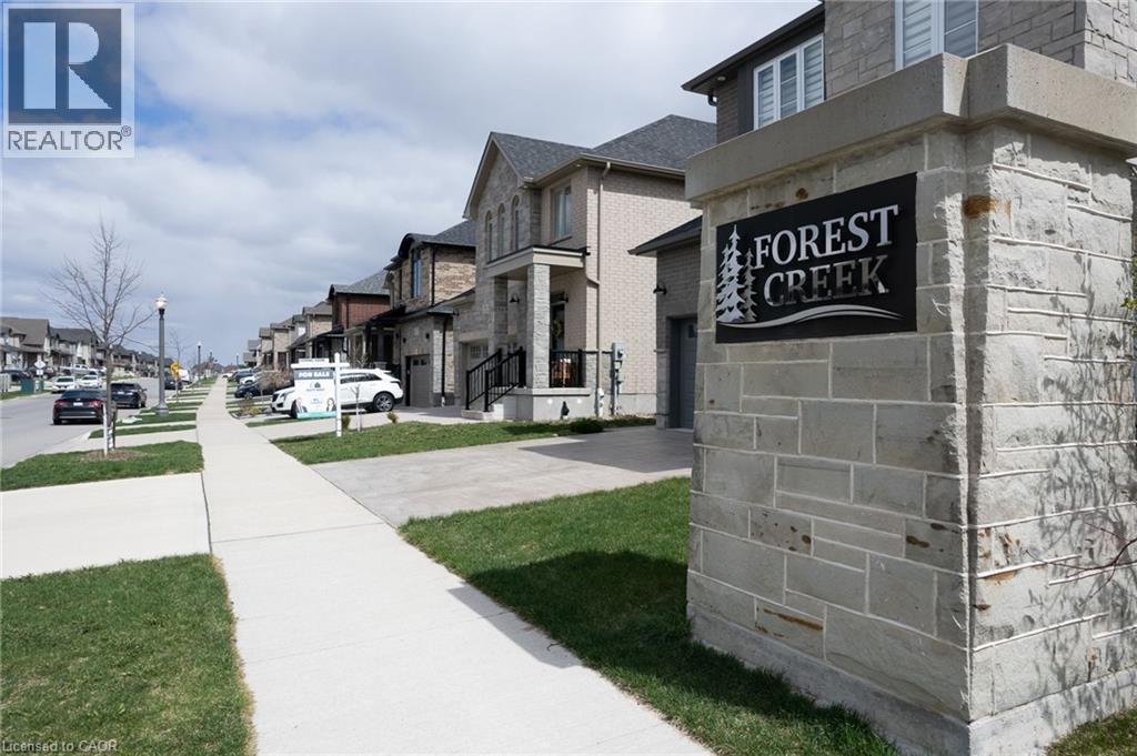 Stone pillar entrance featuring a ""Forest Creek"" sign, defining the community