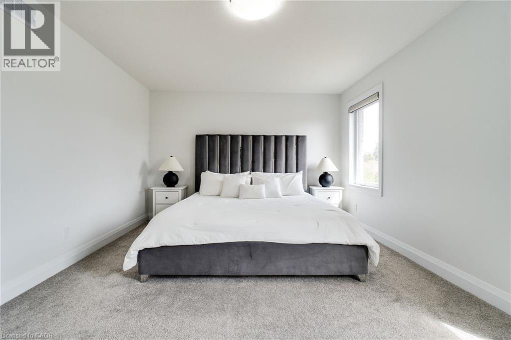 Bedroom featuring neutral wall paint, light-colored carpeting, a single window, white baseboards, and a ceiling-mounted light fixture