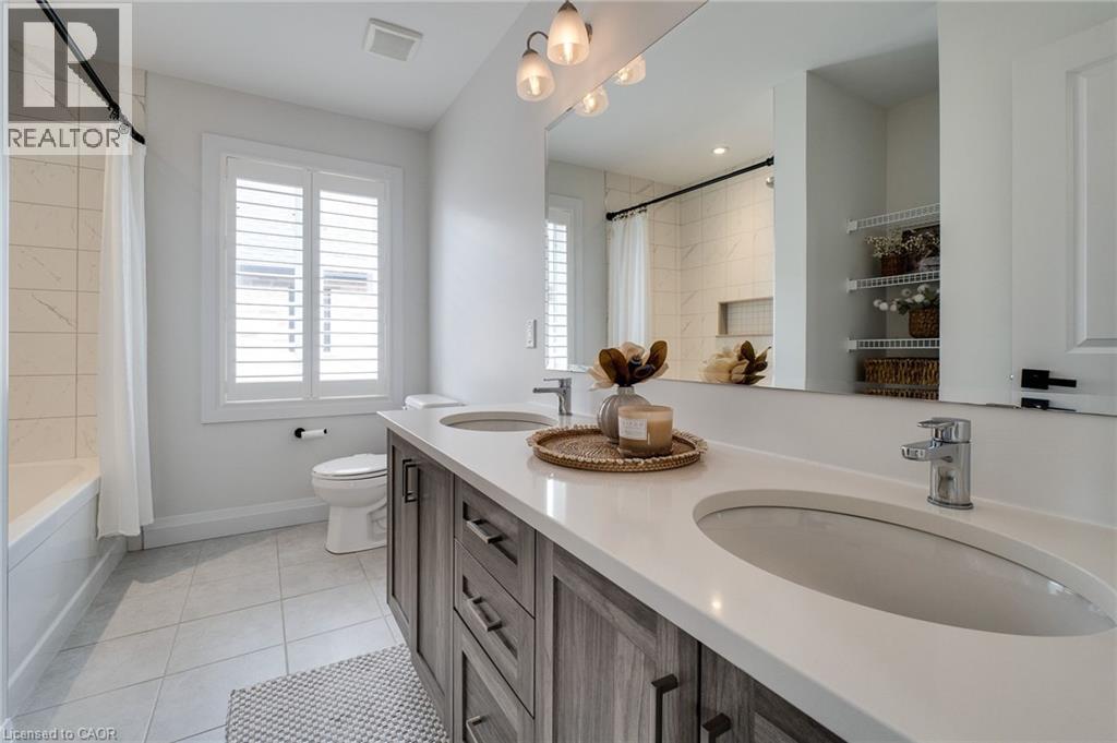 Bathroom featuring a double vanity with wood-finish cabinetry and light-colored countertops
