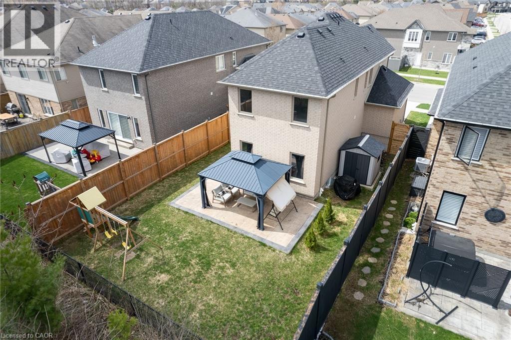 Fenced backyard with a gazebo-covered patio, green lawn, and stepping stone path