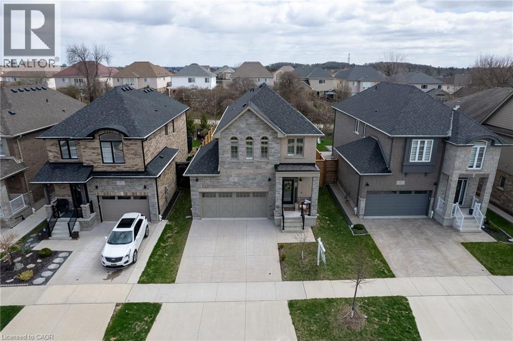 Stone and brick facade featuring a covered entry, arched windows, and a two-car garage