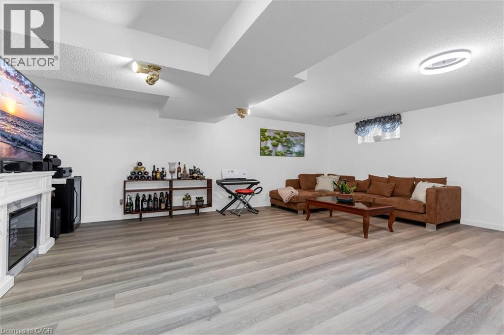 Living room featuring a textured ceiling, light wood finished floors, and a high end fireplace