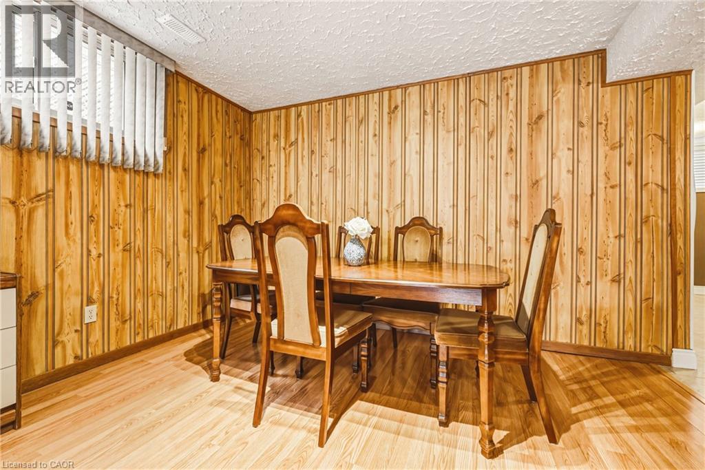 Room featuring extensive vertical wood paneling and light wood-finish flooring