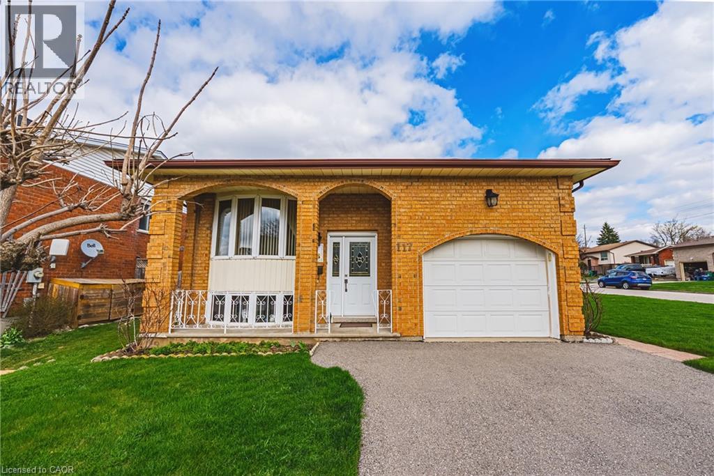 Brick exterior with arched entryways, featuring a single-car garage and a paved driveway