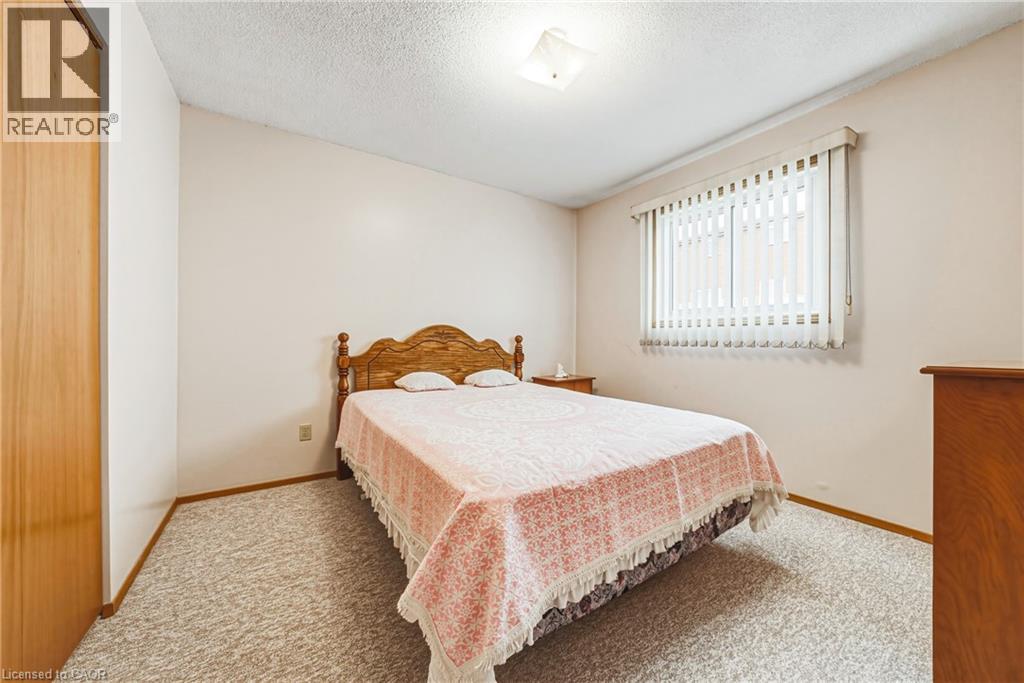 Carpeted room featuring a window with vertical blinds, a light wood-finish built-in closet, and a ceiling-mounted light fixture