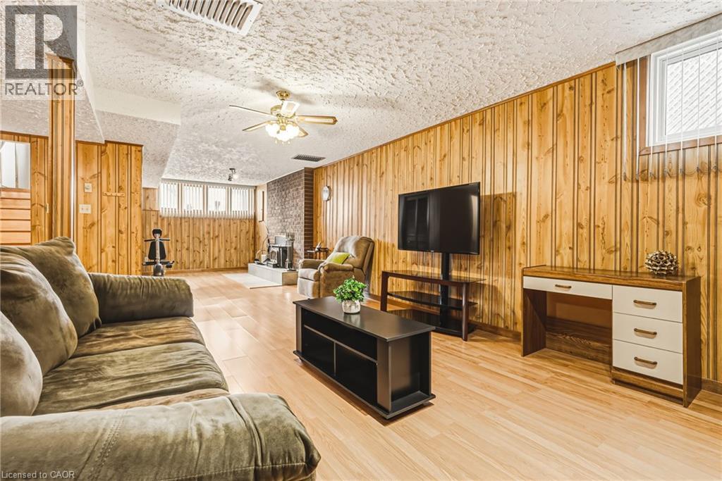 Spacious room featuring wood-finish flooring, paneled walls, and a textured ceiling