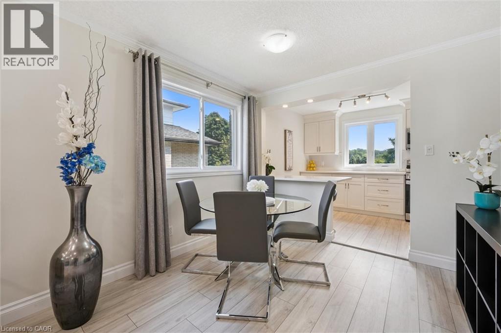 Dining area featuring wood-finish flooring, a large window with natural light, and crown molding