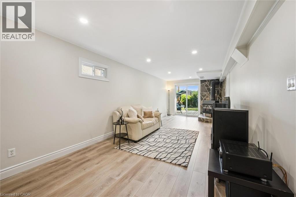 Spacious room featuring light-toned walls, wood-finish flooring, recessed lighting, and a window