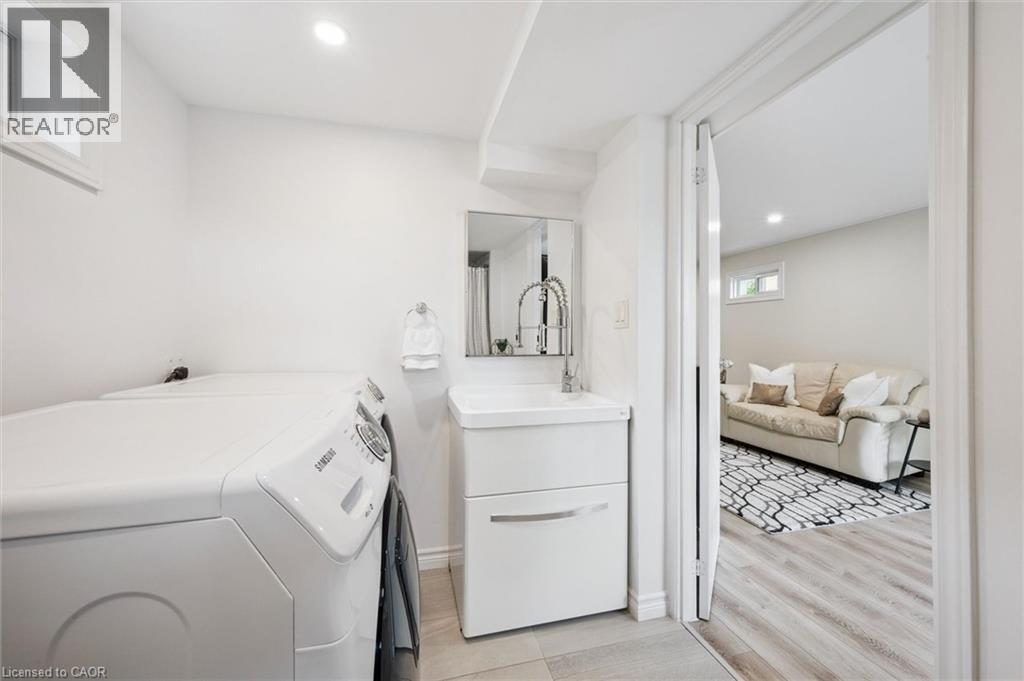 Laundry area featuring a compact vanity with a vessel sink and pull-down faucet, a mirrored medicine cabinet, and recessed ceiling lighting