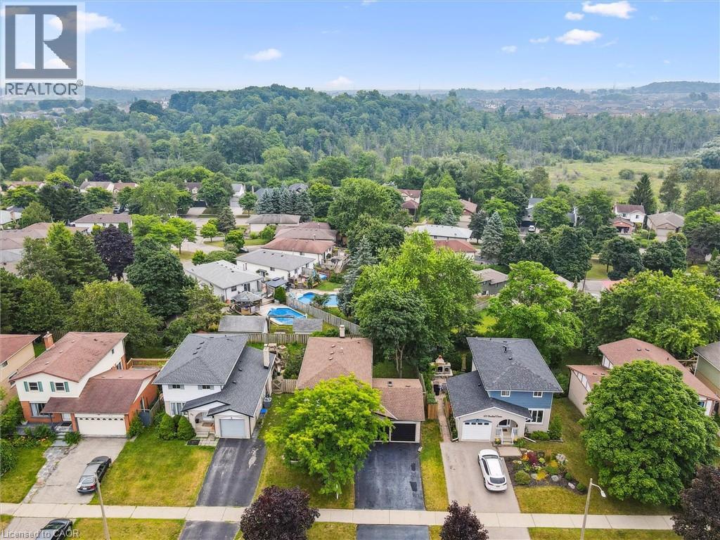 Aerial capture of a residential neighborhood featuring detached homes with varied architectural styles and mature landscaping