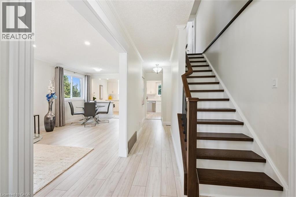 Entryway featuring a dark wood-finish staircase with white risers and a metal baluster