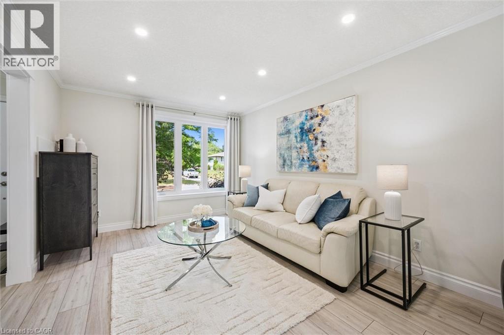 Light wood-finish flooring complements the crown molding and baseboards