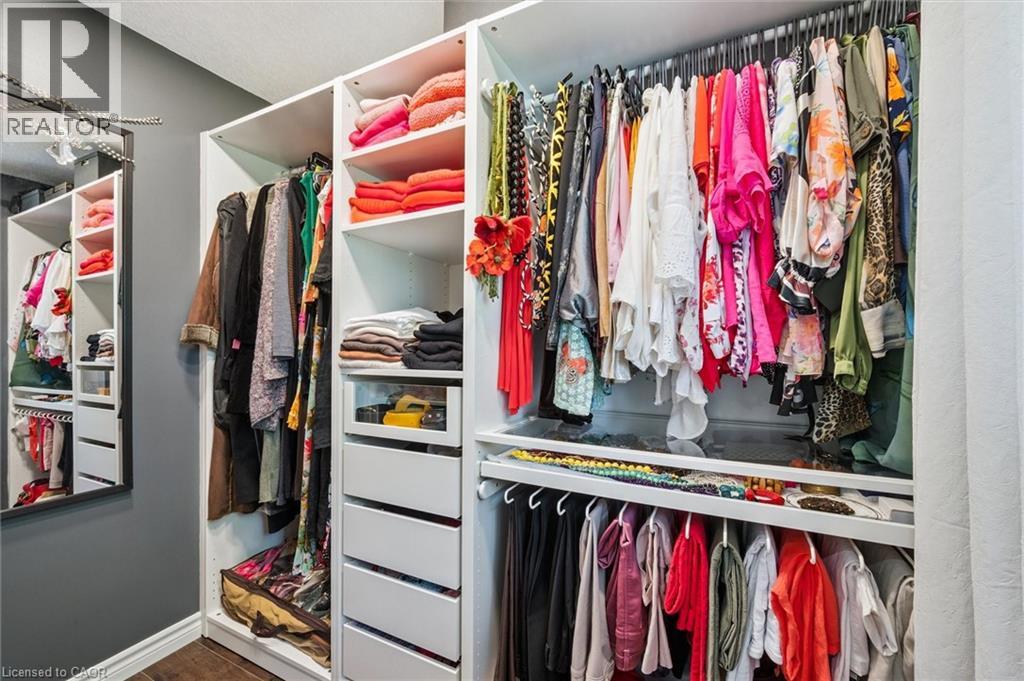 Custom closet system featuring white built-in shelving, multiple hanging rods, integrated drawers, and open storage compartments