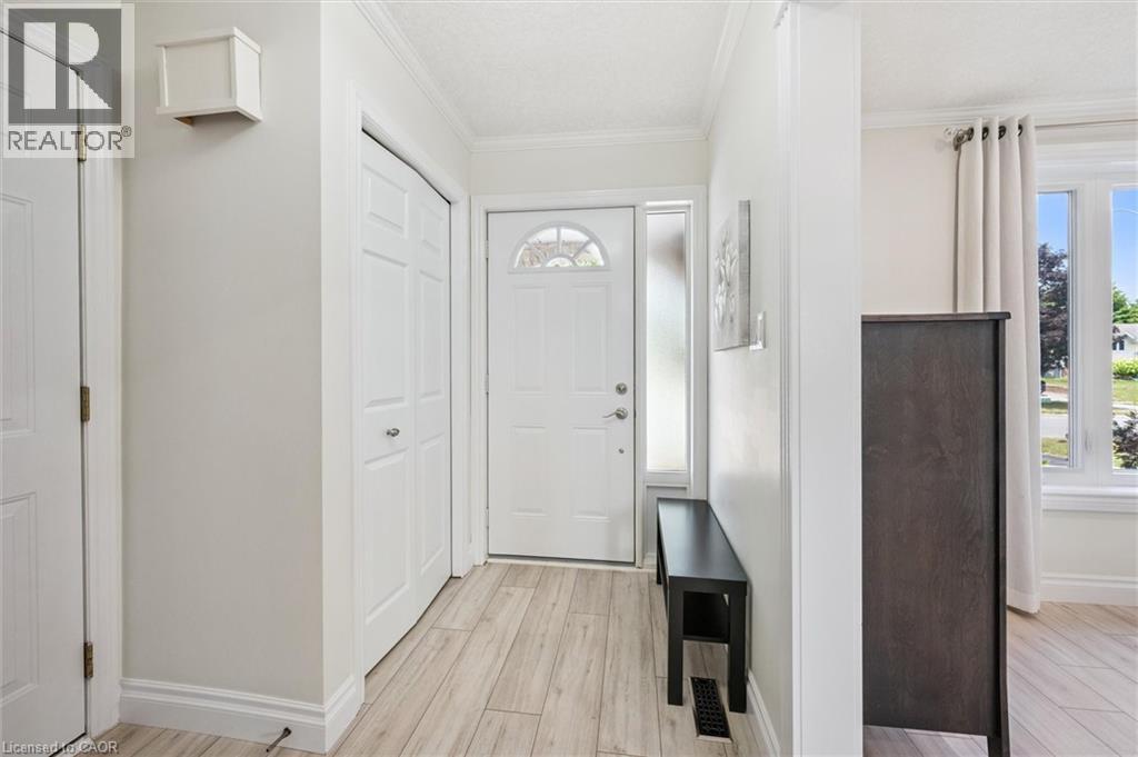 Entryway featuring light wood-finish flooring, white trim, and a frosted sidelight