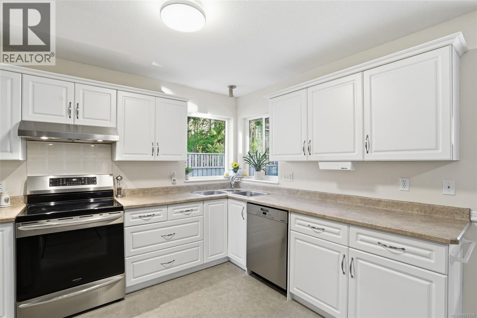 Kitchen sink corner windows with natural light & forest view.