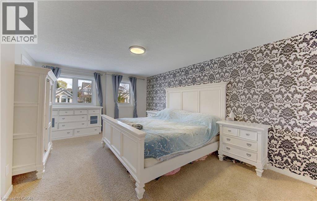 Bedroom featuring a patterned accent wall, carpet flooring, and multiple windows