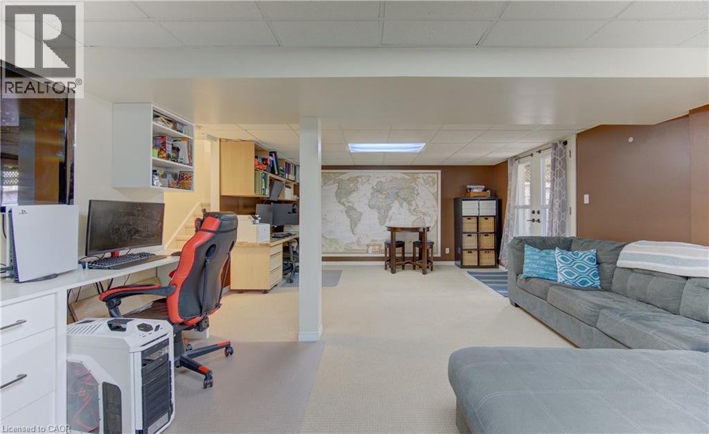 Finished lower level featuring recessed lighting, an integrated desk area, built-in shelving, durable carpeting, and French patio doors