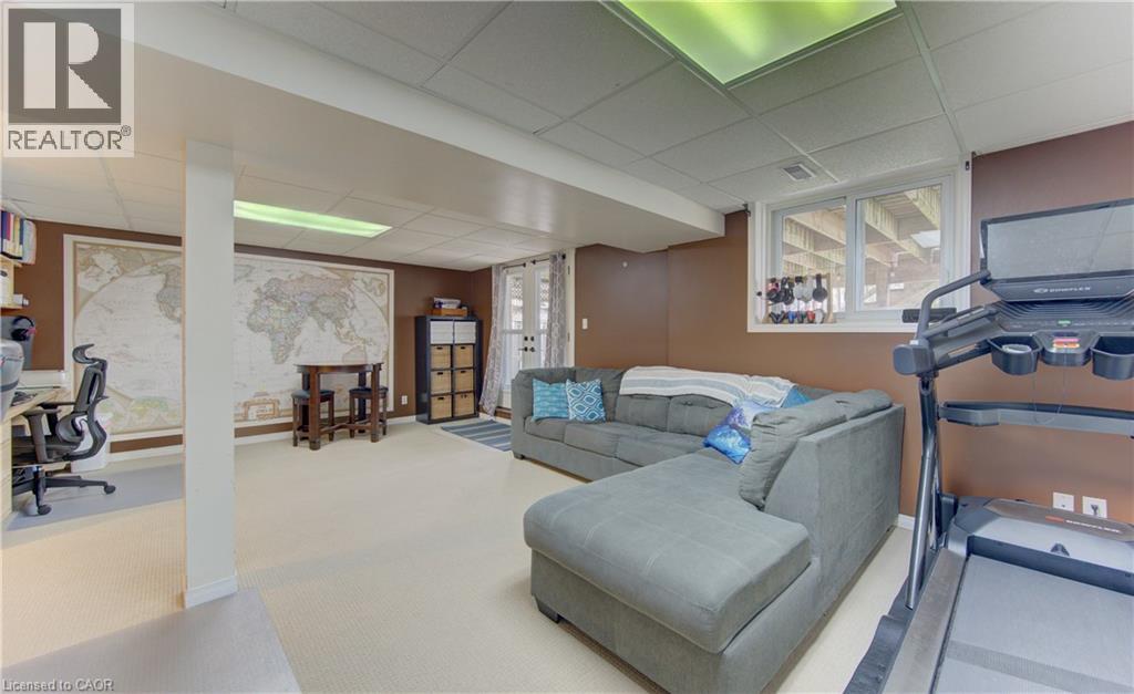 Finished lower level with neutral carpeting, recessed lighting, and a large egress window