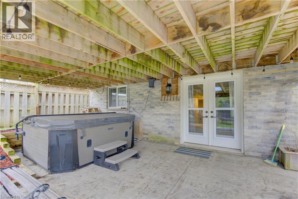 Covered patio area with steps, stamped concrete flooring, and a privacy fence