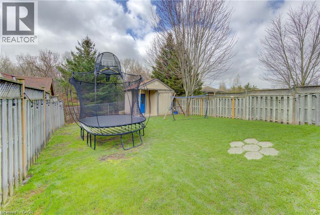 Expansive green lawn with mature perimeter trees and privacy fencing