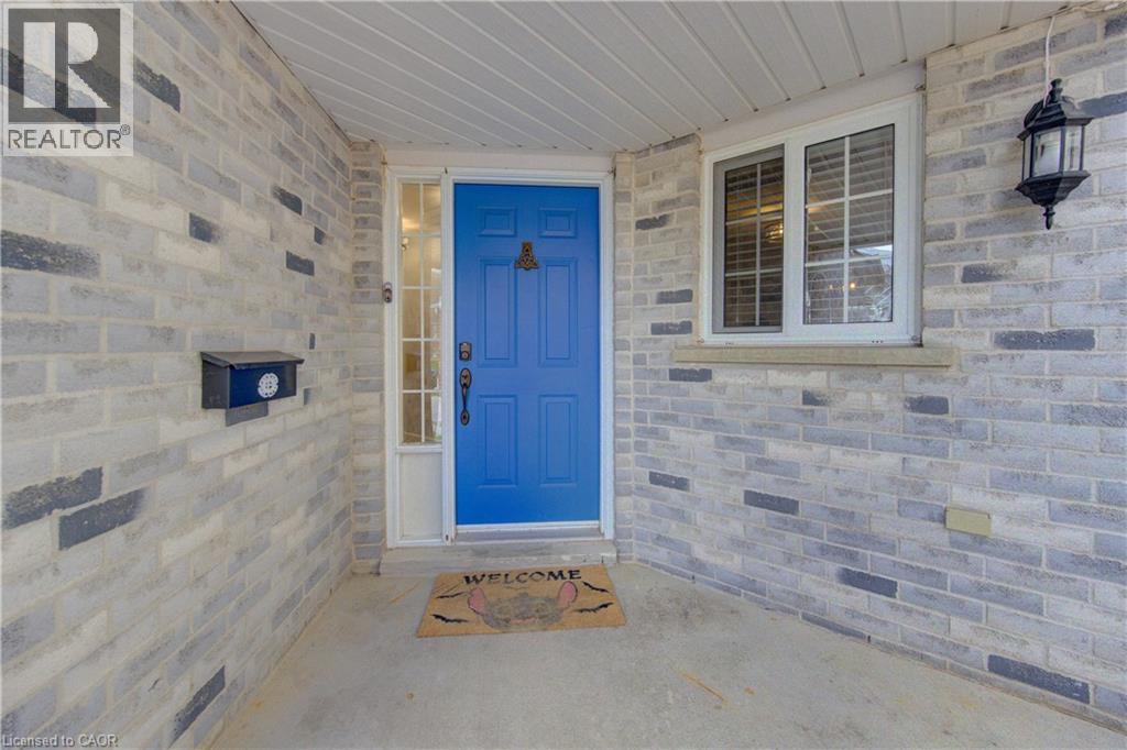 Entryway featuring a blue door with a transom window and sidelight, set against a two-tone brick facade