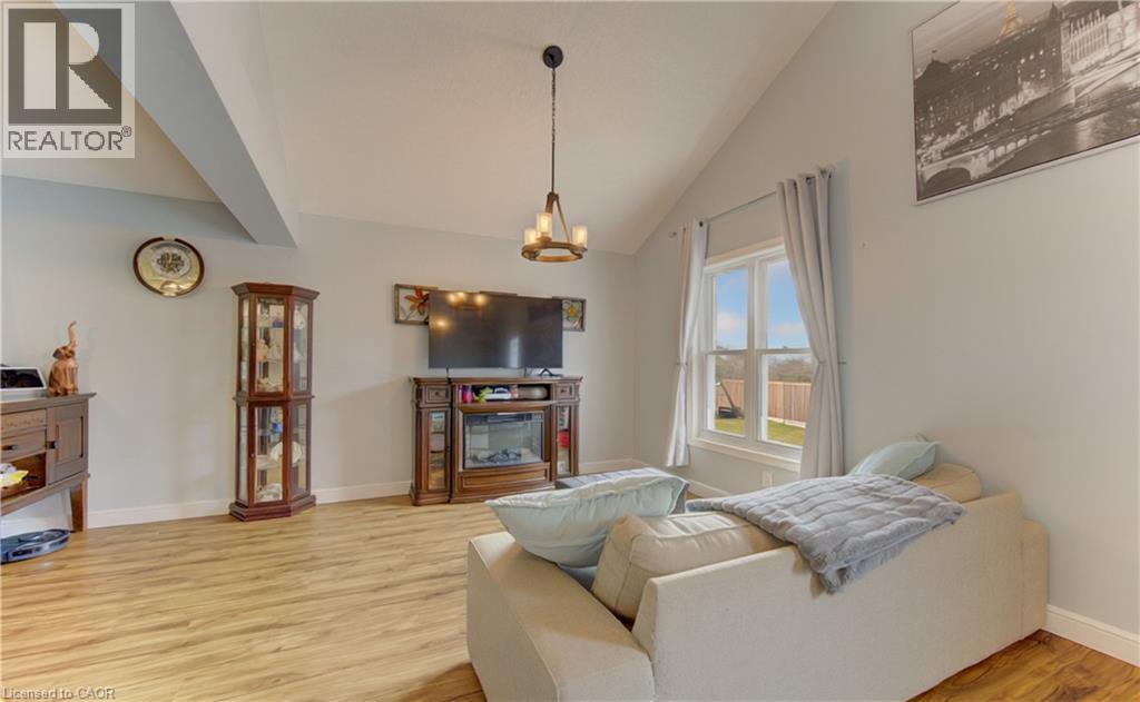Vaulted ceiling with exposed beam, wood-finish flooring, and light-toned wall paint