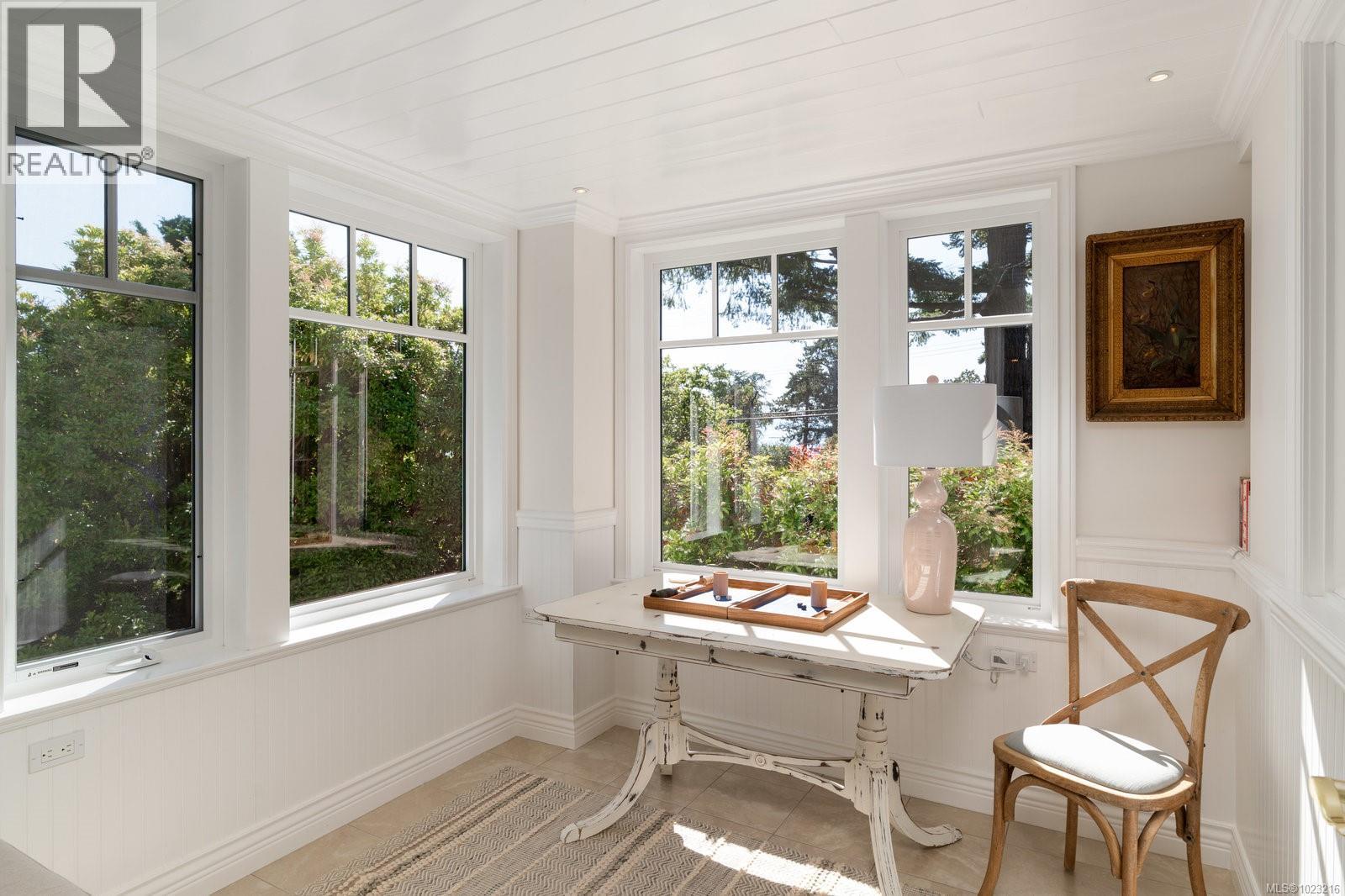 Charming sunroom bathed in natural light and ocean views- perfect for reading, relaxing, or enjoying tea with a view