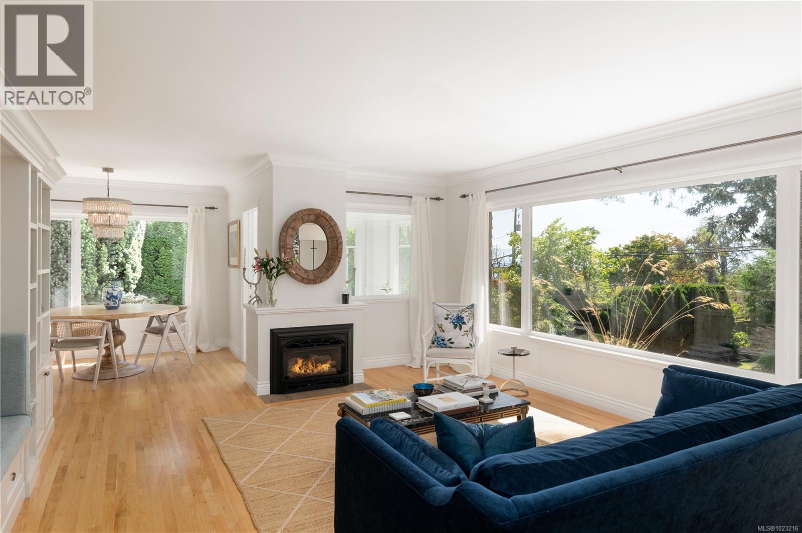 Main living area with gas fireplace and seamless flow to dining and kitchen with ocean view