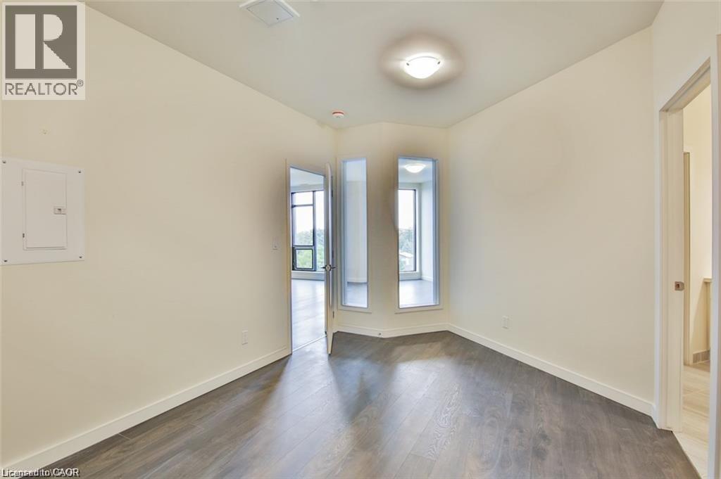 Unfurnished room featuring electric panel and dark wood finished floors