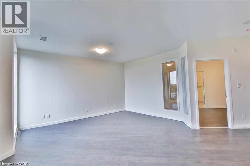 Empty room featuring dark wood finished floors and baseboards