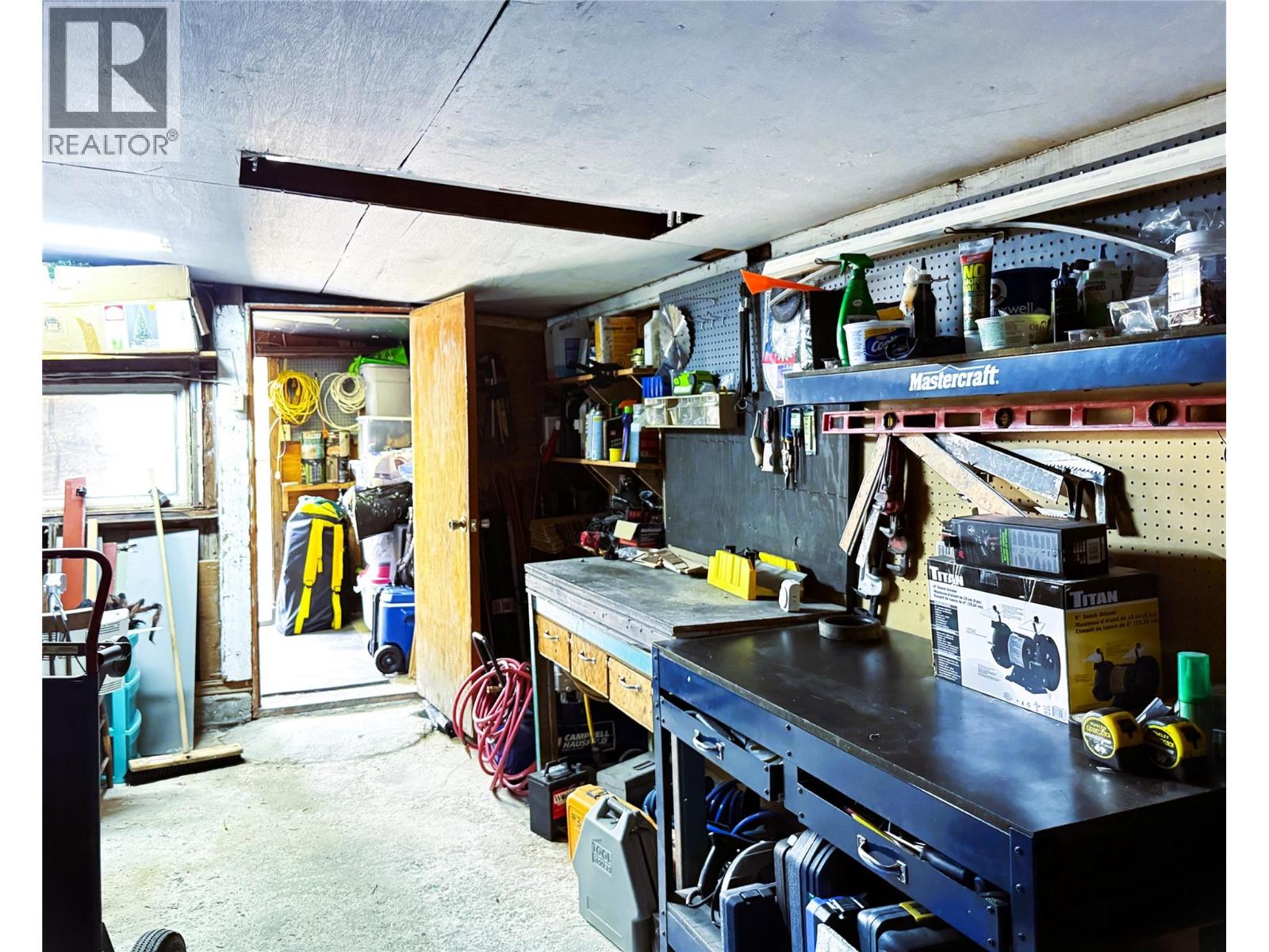 Garage interior. Concrete floor & storage room at back.