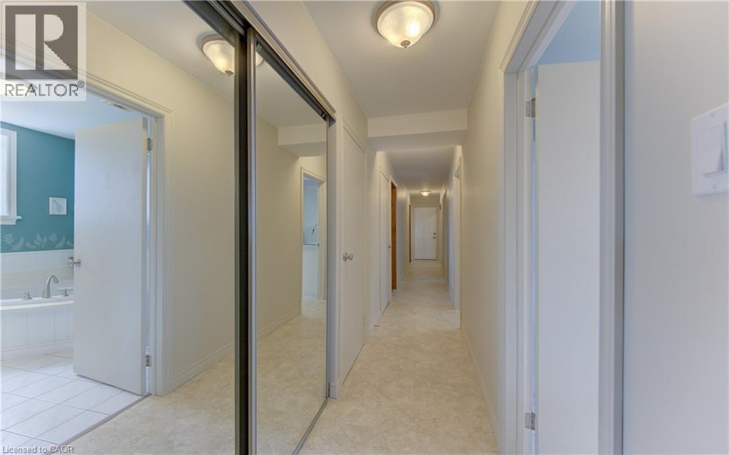 Hallway featuring light-colored wall-to-wall carpeting, overhead dome lighting, and white baseboards