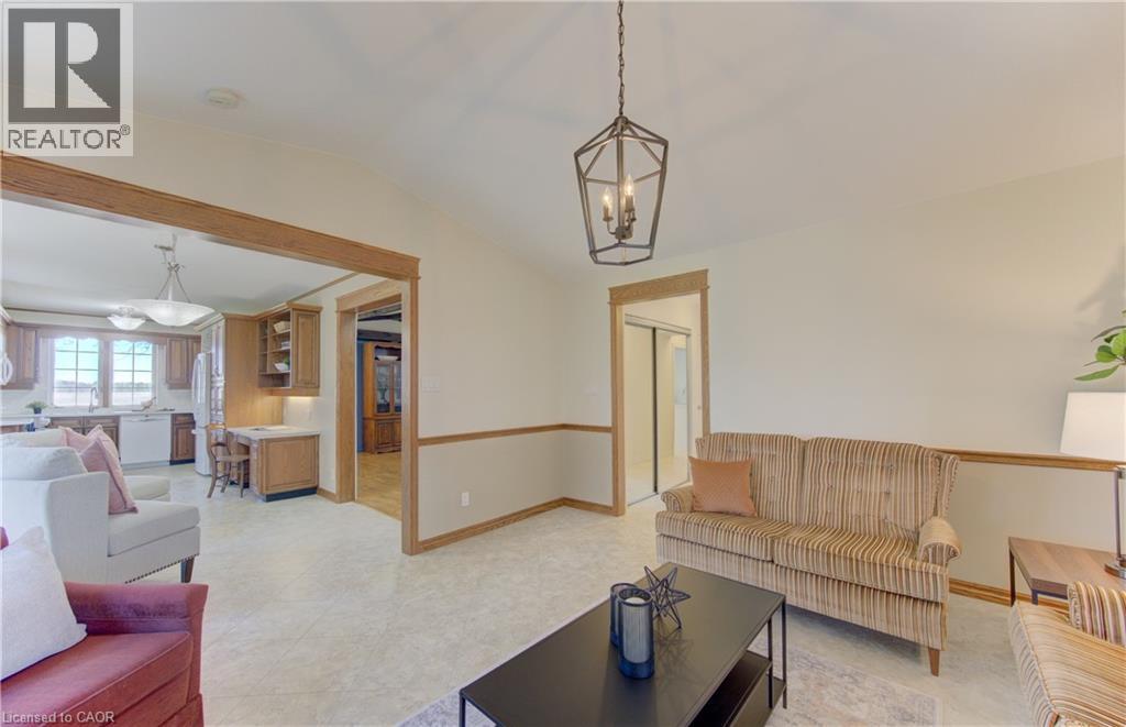 Spacious interior featuring a contemporary ceiling light fixture, neutral wall colors with chair rail molding, and light-toned flooring