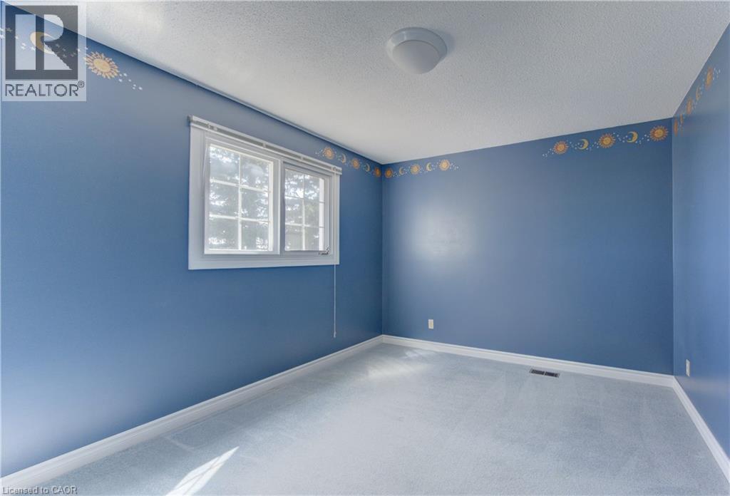 Blue-painted room featuring a double-pane window, carpet flooring, a ceiling-mounted light fixture, and baseboard trim