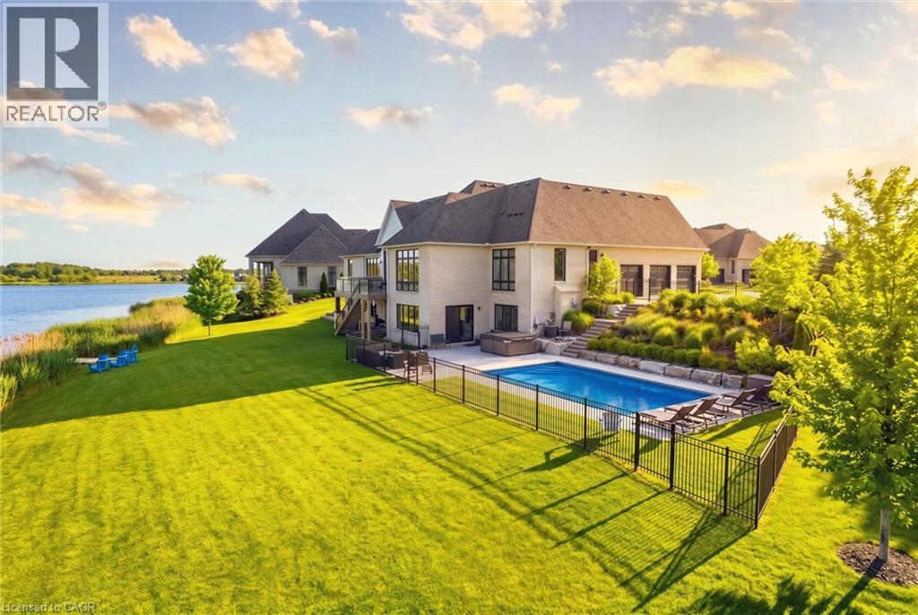 Expansive backyard featuring a manicured lawn, a fenced swimming pool with a surrounding patio, an integrated hot tub, and terraced landscaping